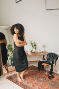 Woman in a sleek black sleeveless dress